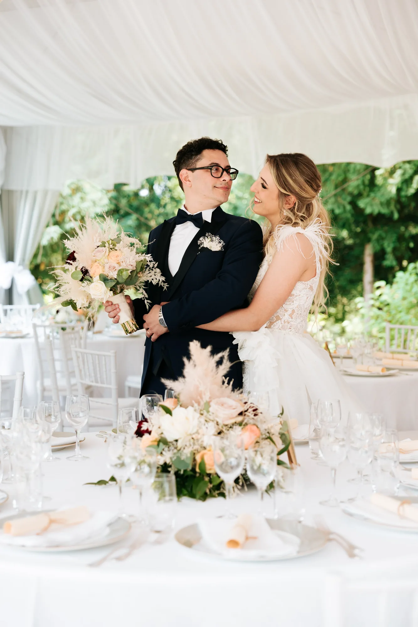 Uno sguardo degli sposi al tavolo del ricevimento — Luméa Wedding
